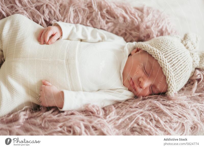 Friedliches Neugeborenes schläft auf weicher rosa Decke Baby neugeboren schlafen friedlich Gelassenheit Säugling Kind gemütlich weiß gestrickt Hut Mittagsschlaf