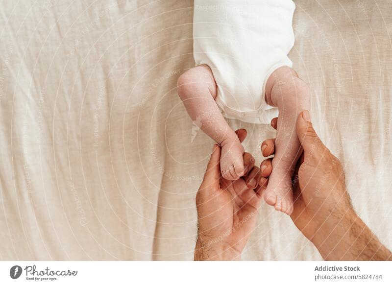 Sanfte Hände halten ein Baby die Füße auf einem weichen Hintergrund Fuß Pflege Angebot Beteiligung Wiege Leinen natürlich Barfuß sanft berühren filigran
