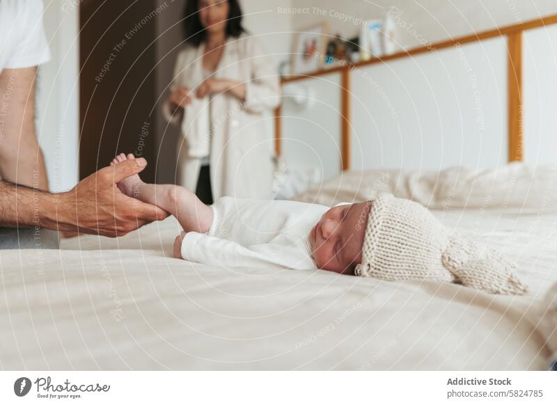 Zärtlicher Moment mit einem neugeborenen Baby und seinen Eltern Bett weiß Kleid sanft Mann Hände Fuß Frau Lächeln Familie Liebe Pflege Zärtlichkeit abstützen