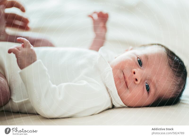 Gelassenes neugeborenes Baby im Liegen bei sanfter Beleuchtung Säugling friedlich Gelassenheit Ausdruck liegend weiche Oberfläche natürliches Licht Windstille