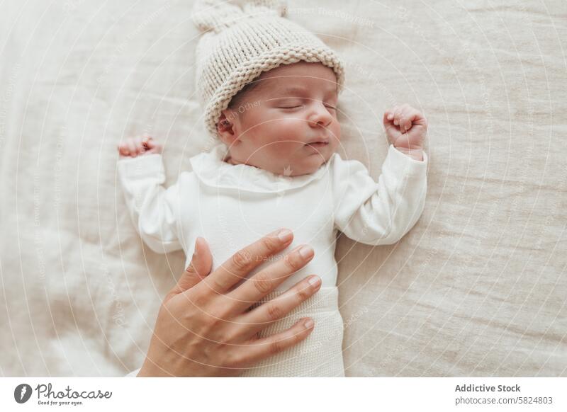 Schlafendes neugeborenes Baby mit Hand auf der Brust schlafen friedlich tröstlich Truhe Strickmütze Säugling ruhen Pflege sanft gemütlich Gelassenheit