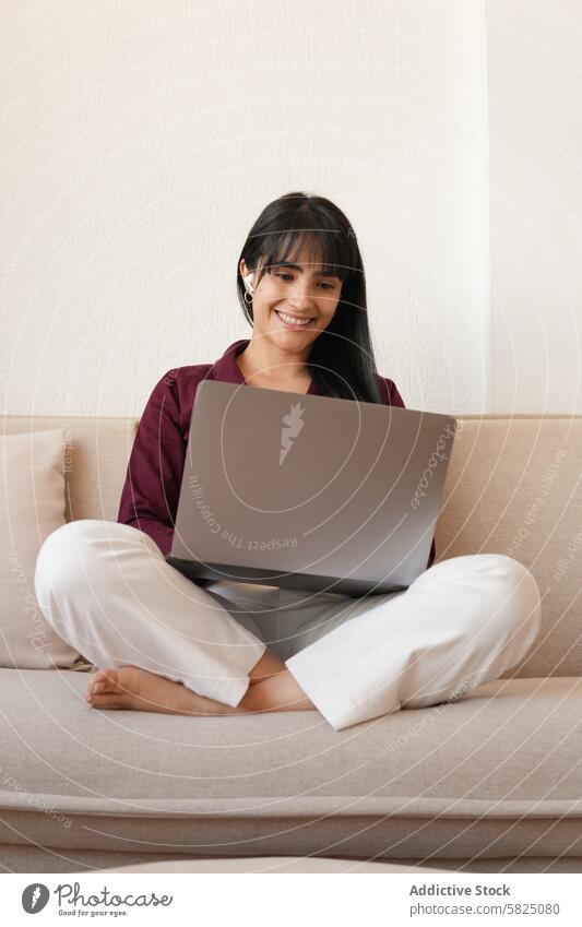 Frau arbeitet bequem zu Hause auf dem Sofa mit Laptop heimwärts Arbeit lässig Sitzen Lächeln online Telekommunikation abgelegen Beschäftigung Internet Business