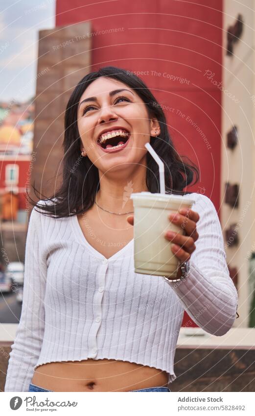 Fröhliche Frau lacht und hält ein Getränk im Freien Lachen trinken urban heiter erfrischend jung Lächeln Großstadt Lifestyle Genuss Freizeit Straße Energie