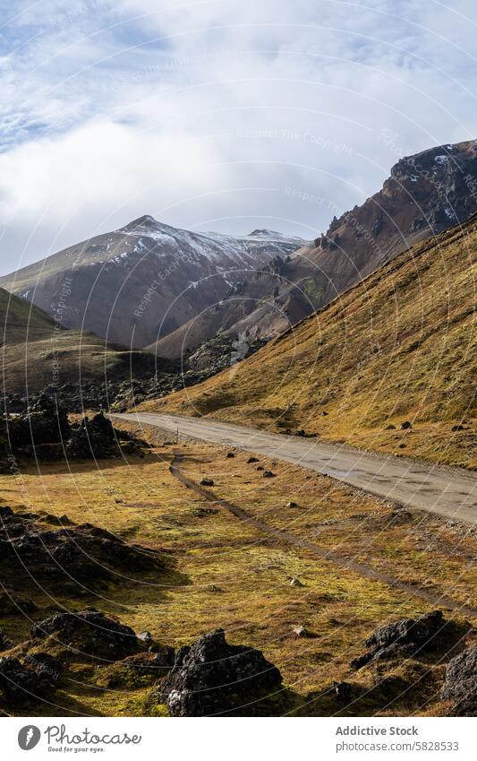 Landschaftlich reizvolle Straße im isländischen Hochland mit Blick auf die Berge Island Highlands malerisch Berge u. Gebirge schneebedeckt robust Gelände Wolken