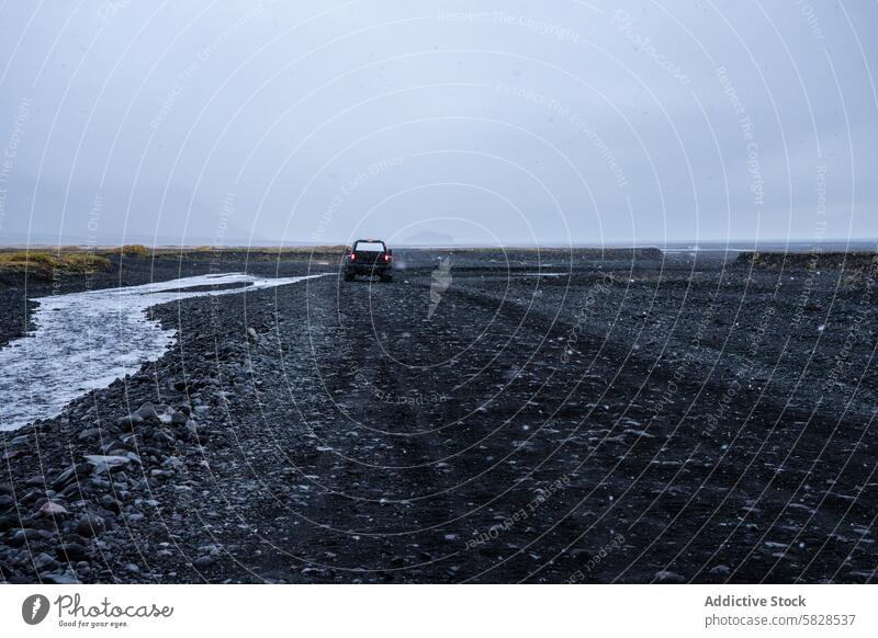 Einsames Fahrzeug auf einer zerklüfteten Straße im isländischen Hochland isländisches hochland reisen Kies desolat Landschaft Stimmung wolkig Himmel