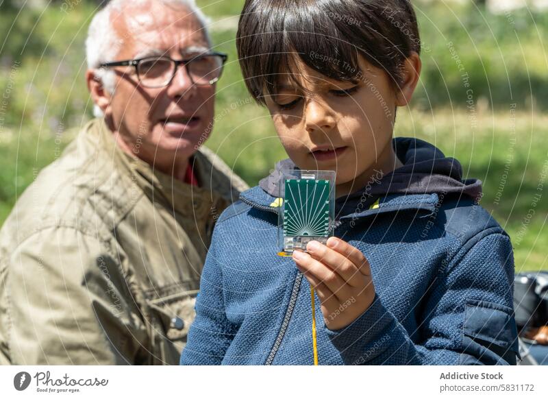 Großvater und Enkel erkunden mit Kompass Natur Frühling erkundend im Freien Abenteuer Lernen Bildung Familie Bonden Wochenende Großeltern Kind Anleitung Regie