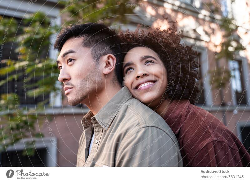 Ein multiethnisches Paar genießt einen gemeinsamen Moment in den pulsierenden Straßen von Madrid Chinesisch hispanisch Spanien Liebe Partnerschaft urban