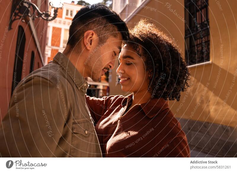 Romantisches multiethnisches Paar auf einer sonnigen Straße in Madrid Liebe Romantik multikulturell interrassisch Fröhlichkeit Lächeln Bonden Partnerschaft