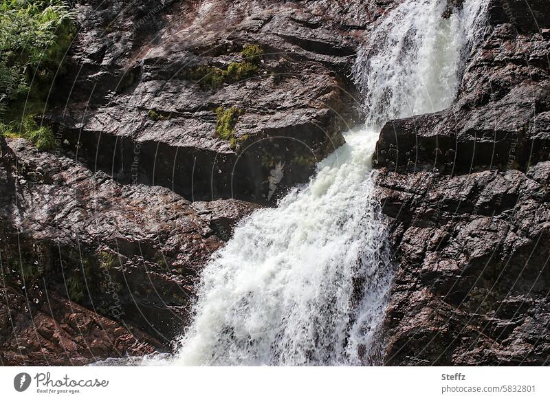 braune Felsen mit einem kleinen Wasserfall in Schottland Hügel Hügelseite Wasserkaskade felsig Wasserfallausschnitt stufig Wasserkraft Wasserrauschen Kraft