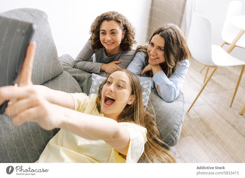 Freunde beim gemütlichen Beisammensein heimwärts Spielen trinken gute Zeit Geschlecht Frauen Selfie Liege Lächeln Spaß haben im Innenbereich lässig Sammeln