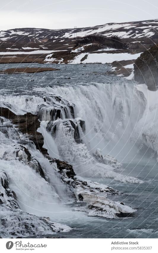 Majestätischer gefrorener Wasserfall in Islands rauer Landschaft Winter Natur eisig fließen felsig Gelände Klippe Kaskade Schnee kalt im Freien malerisch