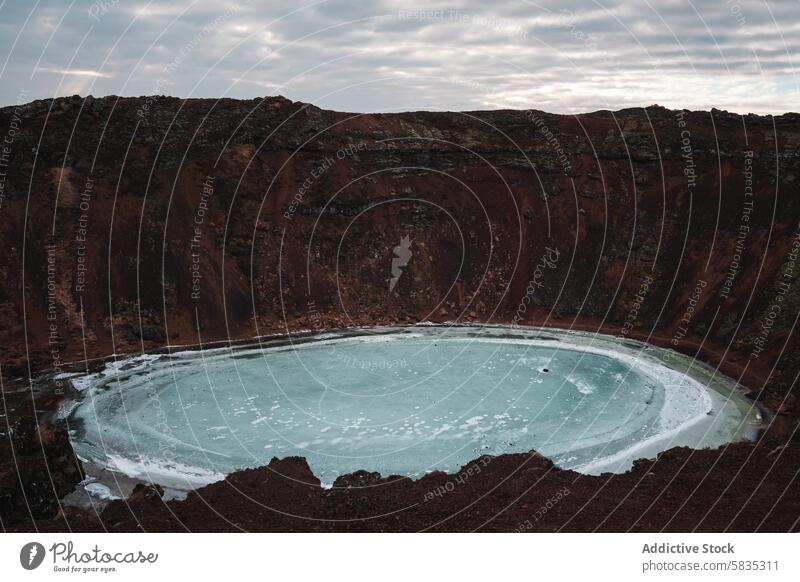 Blick auf einen gefrorenen Kratersee in Islands zerklüfteter Landschaft See Snæfellsnes Halbinsel Stimmung Himmel rot Felsen Isolation Schönheit Gelände Natur