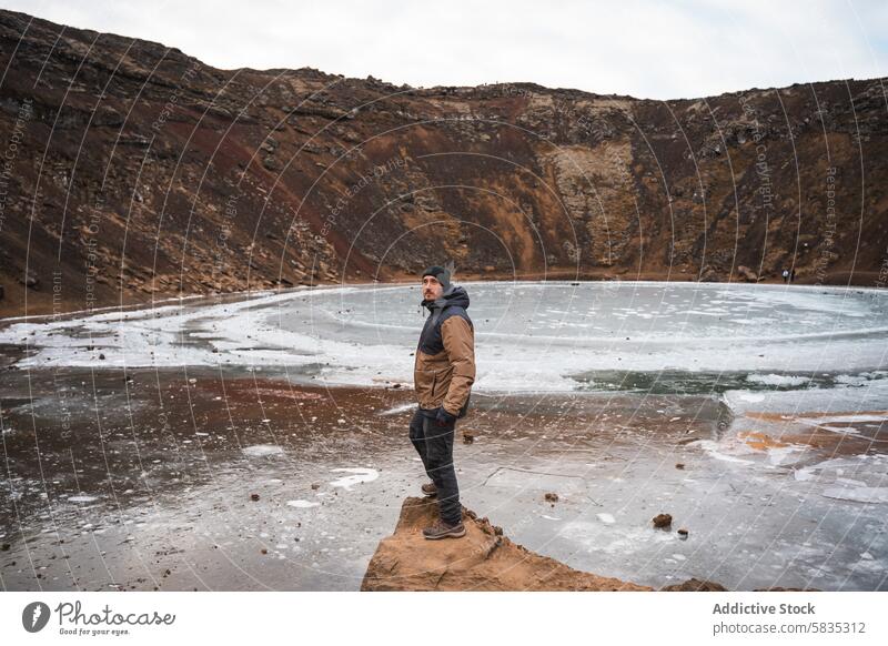 Ein Mann steht an einem gefrorenen Vulkankrater in Island Reisender Snæfellsnes Halbinsel Eis Winter Einsamkeit Landschaft Natur reisen Erkundung kalt robust