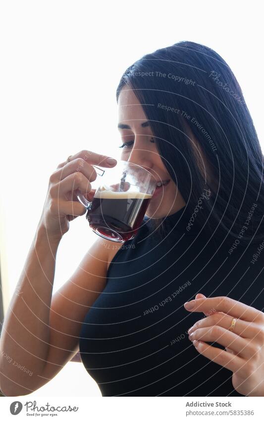 Frau genießt ihren Kaffee in einer ruhigen Umgebung trinken Morgen Getränk friedlich jung dunkles Haar Tasse Verkostung helle Einstellung Genuss