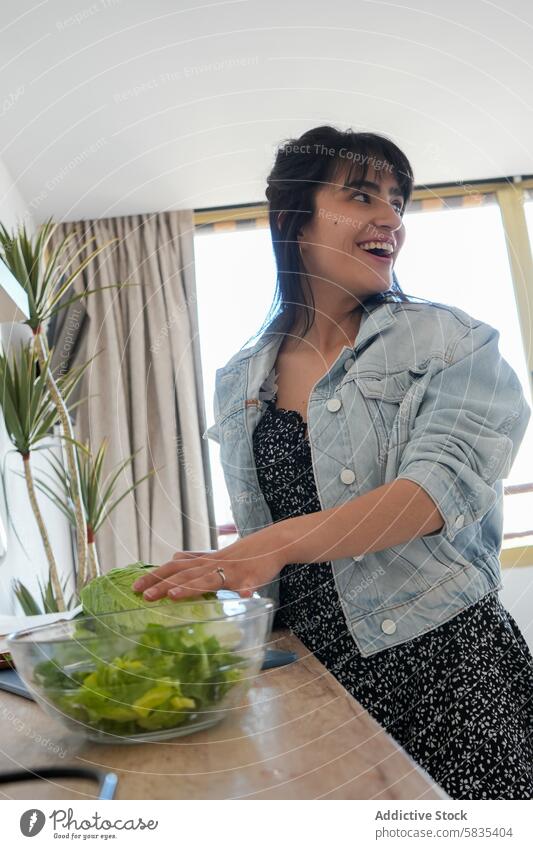 Lächelnde Frau bei der Zubereitung von Salat in ihrer Küche Essen zubereiten Salatbeilage Fröhlichkeit Gesundheit lässig heimwärts häusliches Leben Freude