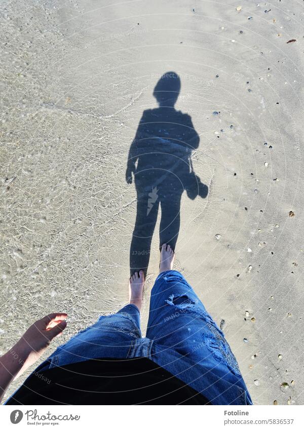 Barfuß laufe ich am Strand von Helgoland entlang. Mein Schatten verrät, dass ich meine Kamera dabei habe und auf Motivsuche bin. Licht & Schatten