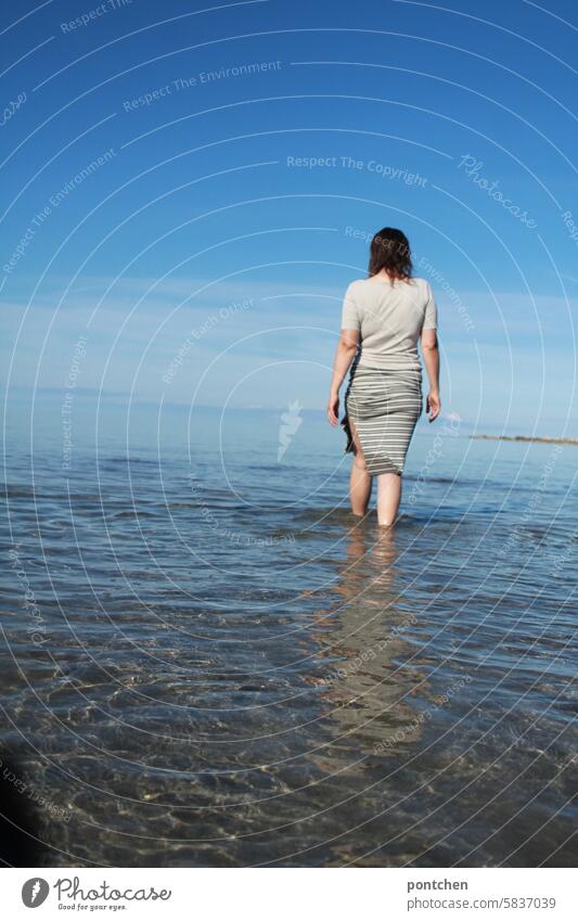 eine bekleidete frau water im meer. waten erfrischung genuss wasser nass Ferien & Urlaub & Reisen Freude rock modisch rücken körper Außenaufnahme himmel blau