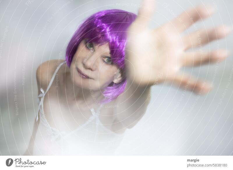 Eine feminine Frau mit lila Haaren winkt freundlich Porträt Mensch Gesicht Erwachsene Innenaufnahme Hand winken schemenhaft Kopf Augen weiblich Hemd Blick