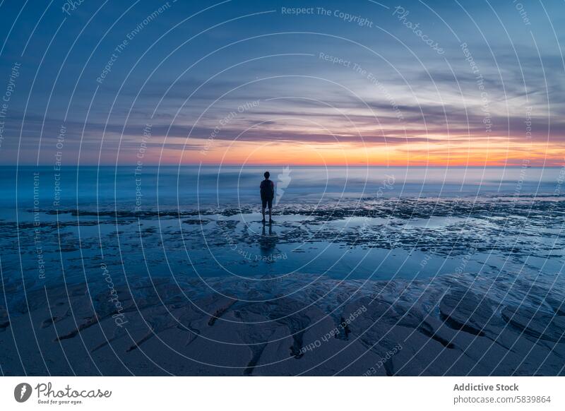 Anonyme Person bewundert den Sonnenaufgang am Atlanterra Beach mit einsamer Figur Atlanterra Strand MEER Silhouette Horizont friedlich Morgendämmerung Cadiz