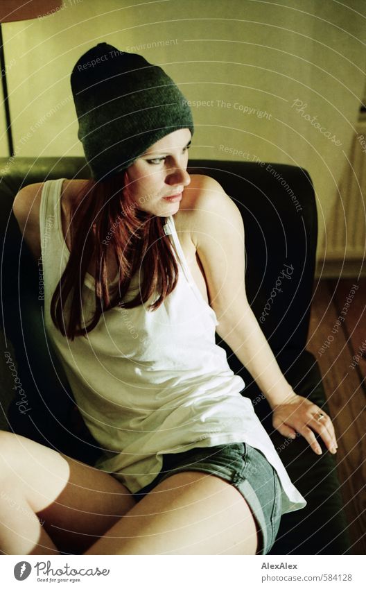 Seitenwechsel Junge Frau Jugendliche 18-30 Jahre Erwachsene Hemd Mütze Hotpants rothaarig langhaarig Sofa beobachten sitzen ästhetisch sportlich außergewöhnlich