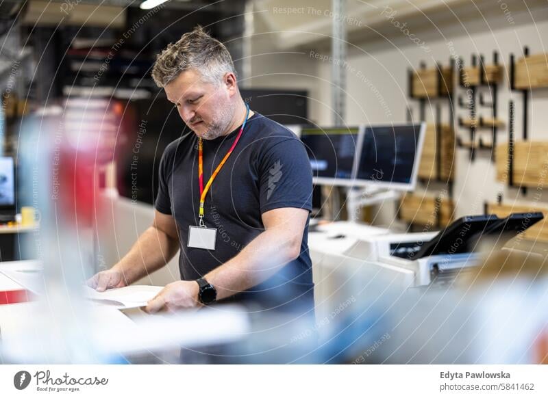 Mann bei der Arbeit in einer Druckerei Business Mitarbeiter Fabrik männlich industriell Industrie Job Güterverkehr & Logistik Herstellung Beruf Menschen