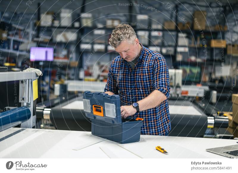 Mann bei der Arbeit in einer Druckerei Business Mitarbeiter Fabrik männlich industriell Industrie Job Güterverkehr & Logistik Herstellung Beruf Menschen