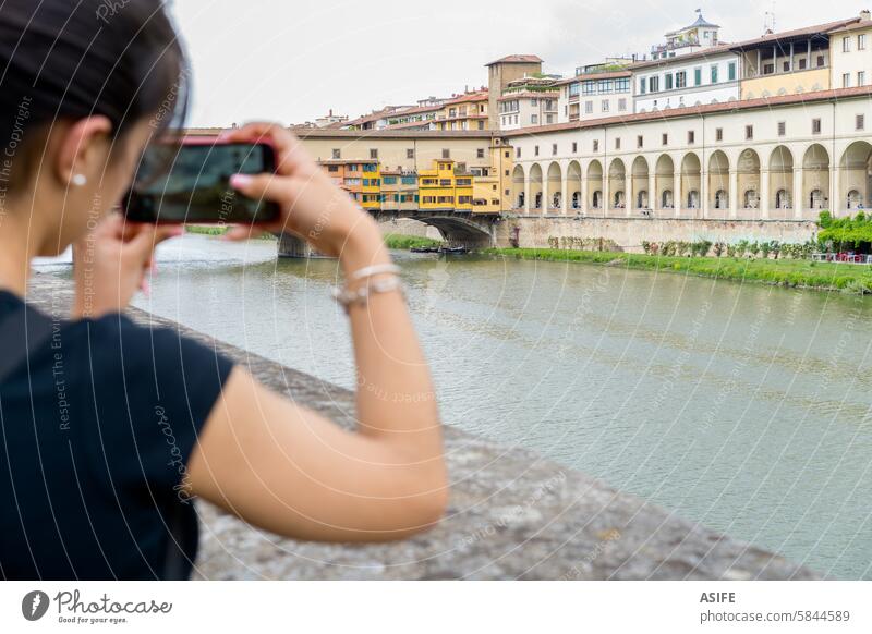 Junger Fotograf, der die Vecchio-Brücke in Florenz mit einem Smartphone fotografiert Mobile Tourist Fotografieren Telefon Großstadt Italien Mädchen Frau jung