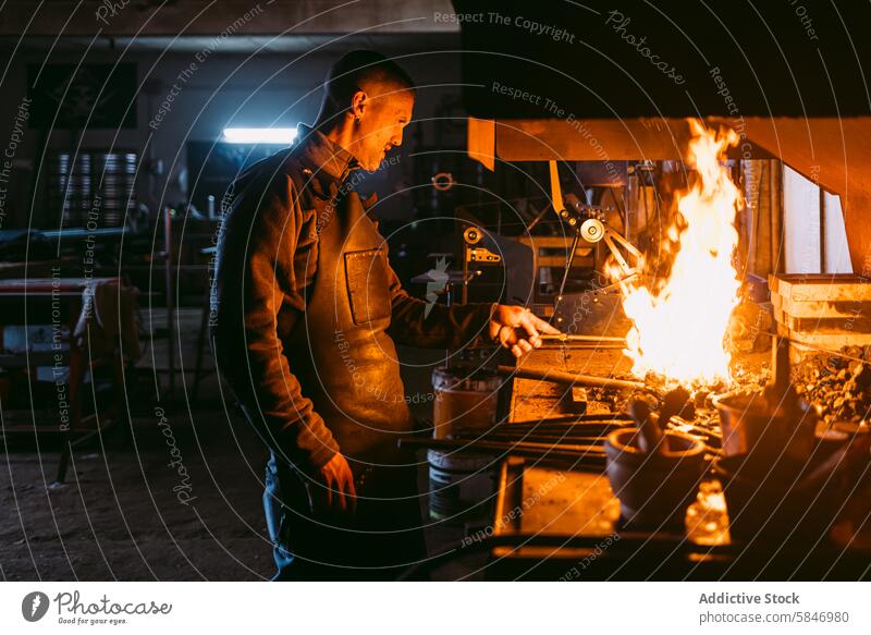 Schmied in traditioneller Werkstatt beim Schmieden von Metall Hufschmied heiß schmieden Handwerkskunst männlich Arbeit Feuer Beruf Kunstgewerbler Industrie