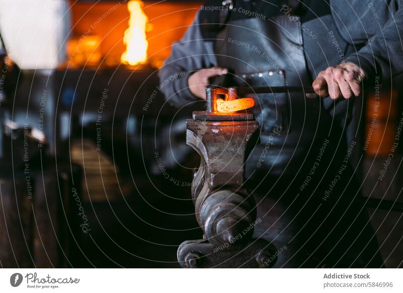 Schmied beim Schmieden von heißem Metall auf dem Amboss in der Werkstatt Hufschmied Hammer erwärmen Form traditionell Handwerk manuell Arbeit bügeln glühend