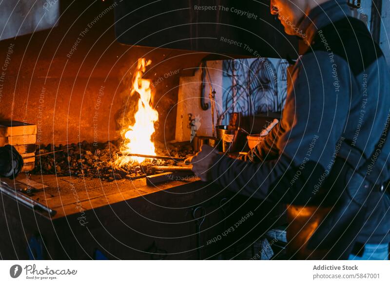 Schmied erhitzt Metall in der Schmiede in der Werkstatt Hufschmied schmieden Heizung Handwerk Kompetenz Arbeit Feuer Flammen traditionell Handwerkskunst