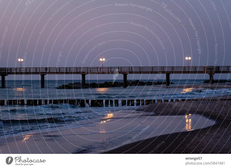 Lichter der Wustrower Seebrücke spiegeln sich im Wasser der Ostsee Fischland Lampen Lampenschein Spiegelung Reflexionen Abend Abenddämmerung Meer Küste Strand