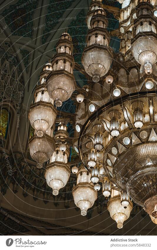 Prächtige Kronleuchter in einer verzierten Moschee im Oman Zimmerdecke islamisch Design Handwerkskunst Innenbereich elegant Kaskade Dekor Architektur Licht