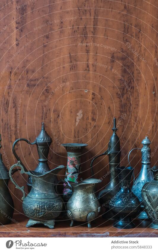 Traditionelle omanische Metallarbeiten auf einem hölzernen Hintergrund Handwerkskunst Metallbearbeitung Kannen Vase traditionell rustikal verziert Sammlung