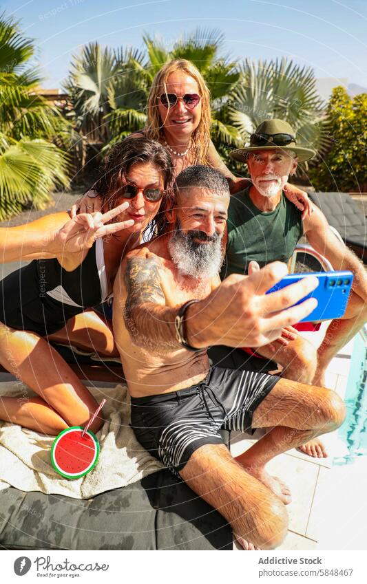 Fröhliche Seniorenfreunde machen ein Selfie am Pool Freund Sommer tropisch heiter sonnig Tag Menschengruppe einfangen Moment pulsierend Schwingung Baum