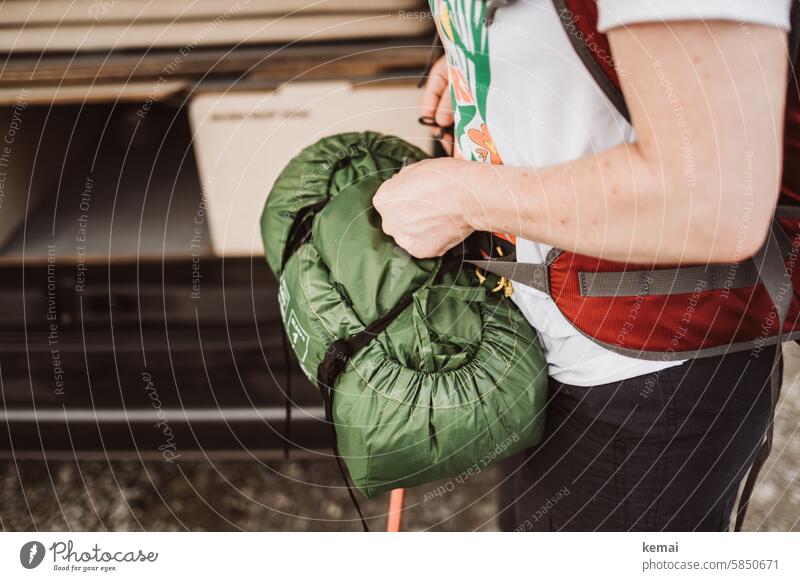 Frau macht sich bereit zum Wandern und Campen Zelt Camping Rucksack bereit machen Arm Hand packen verpackt