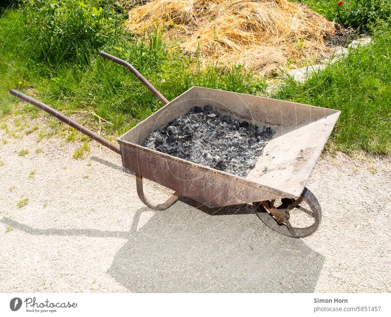 Asche in einer alten Schubkarre verbrannt Reste Bauernhof Landwirtschaft Misthaufen Gartenarbeit ländlich stabil Nutzwert Verwertung Entsorgung transportieren