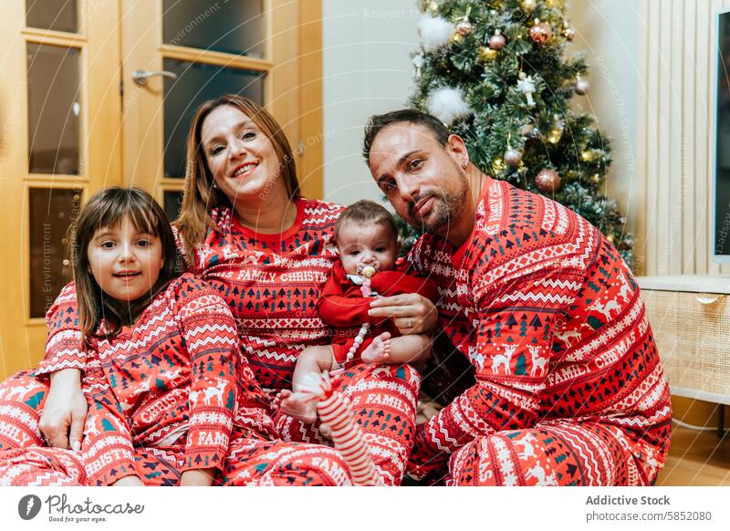Gemütlicher Familien-Weihnachtsmoment mit passenden Outfits Weihnachten Passende Pyjamas Lächeln gemütlich Feiertag festlich Saison Tradition Kinder Eltern