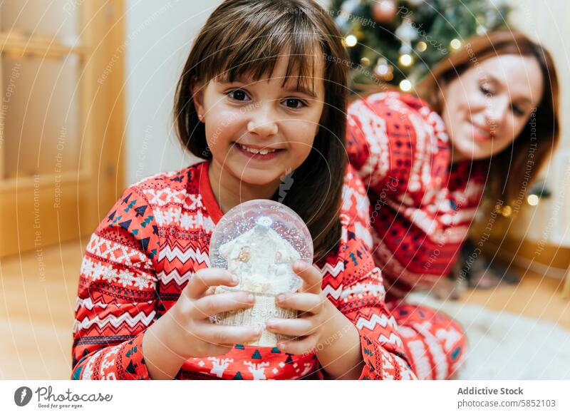 Familienfreude mit Weihnachtsschneekugel Mutter Weihnachten Freude Schneekugel kleines Mädchen Frau Mama Feier Lächeln festlich Pullover Feiertag Kind Tochter