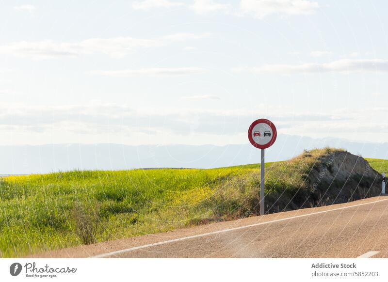 Malerische Straßenlandschaft mit einem Überholverbotsschild Landschaft grüne Wiese Klarer Himmel malerisch ruhig Verkehrsgebot Verkehrssicherheit reisen