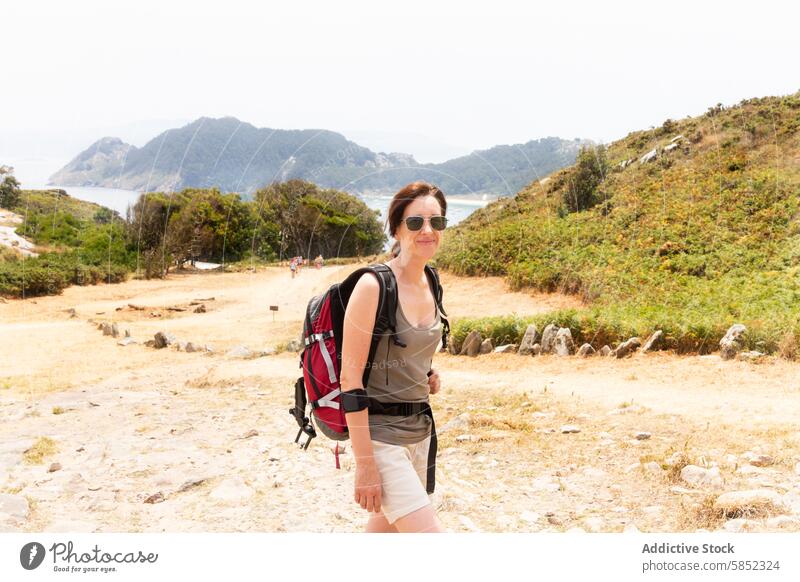 Wanderer genießt eine sommerliche Küstenlandschaft Frau Rucksack Lächeln Küstenwanderweg Natur MEER Ansicht Sommer Landschaft im Freien reisen Abenteuer