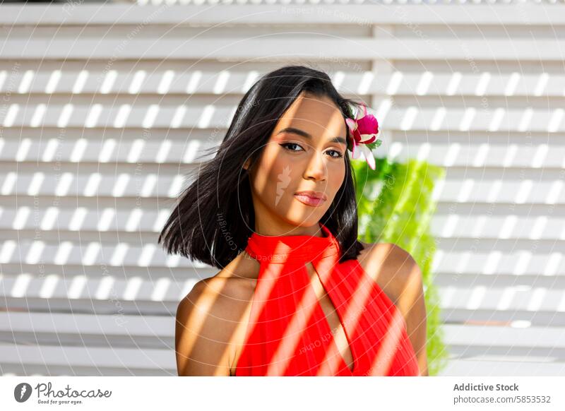 Elegante Frau mit tropischer Blume im roten Kleid elegant Behaarung Pose Hintergrund Muster pulsierend Dame Mode Stil schick Schönheit attraktiv Porträt