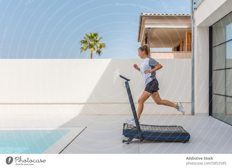 Junge Frau beim Training auf dem Laufband im Freien Übung Fitness Athlet rennen Pool Himmel sonnig tropisch Palme modern Gesundheit Wellness aktiv Lifestyle