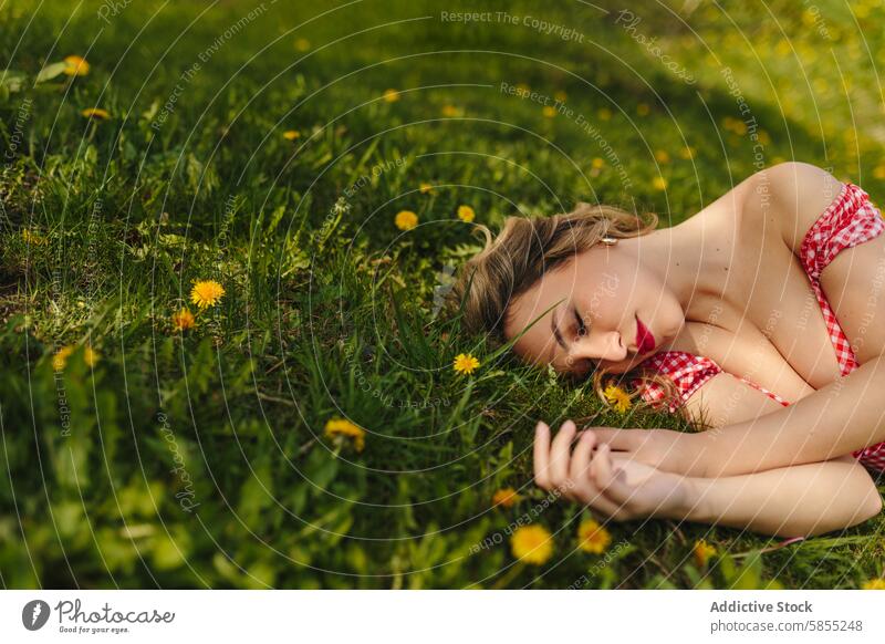 Frau entspannt sich allein in einem grasbewachsenen Feld mit Löwenzahn Gras Sonnenlicht Gelassenheit friedlich Erholung Sommer Natur im Freien grün geblümt