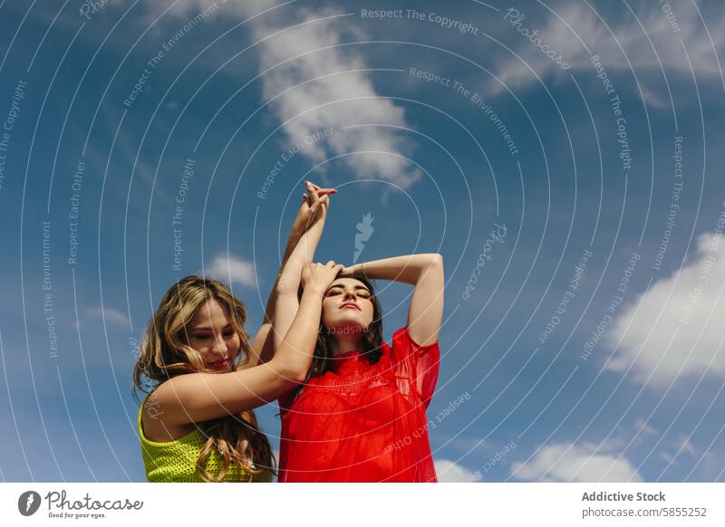 Junge Frauen genießen den sonnigen Tag im Freien Freund Freizeit spielen Himmel blau Cloud Genuss Jugend spielerisch Aktivität Freundschaft lässig Freiheit