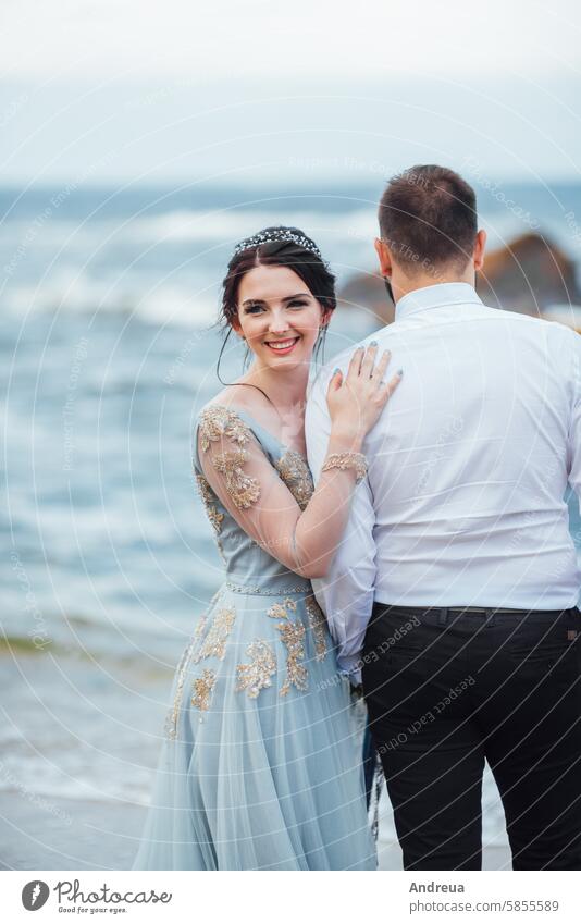 dasselbe Paar mit einer Braut in einem blauen Kleid geht Erwachsener Strand schön Schönheit Küste Farbe Konzept Frau Freiheit Mädchen striegeln Hände