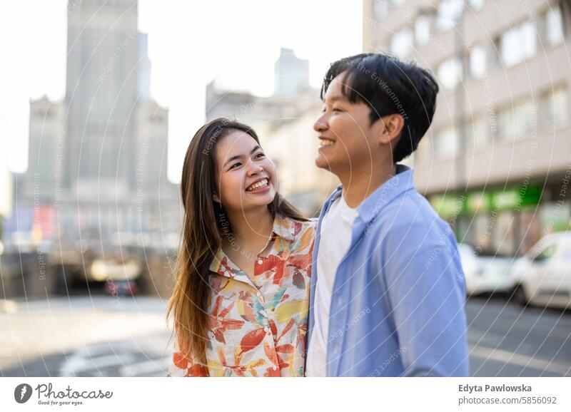 Glückliches junges Paar auf einer Stadtstraße asiatisch echte Menschen Spaß genießend junger Erwachsener authentisch heiter selbstbewusst Frau Freude