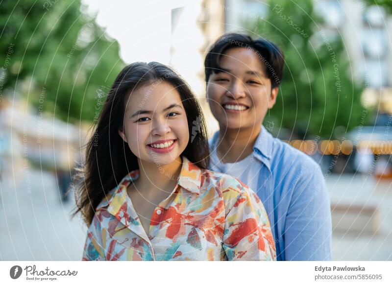 Glückliches junges Paar auf einer Stadtstraße asiatisch echte Menschen Spaß genießend junger Erwachsener authentisch heiter selbstbewusst Frau Freude
