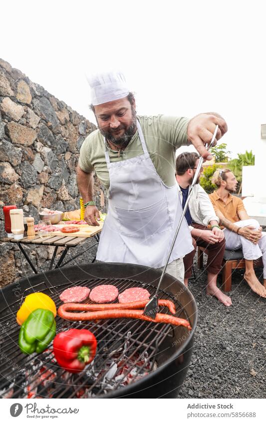 Grillparty im Freien mit Freunden bei Essen und Musik Barbecue Lebensmittel Küchenchef Gespräch Grillrost Hut Schürze Essen zubereiten Fleisch Gemüse Party