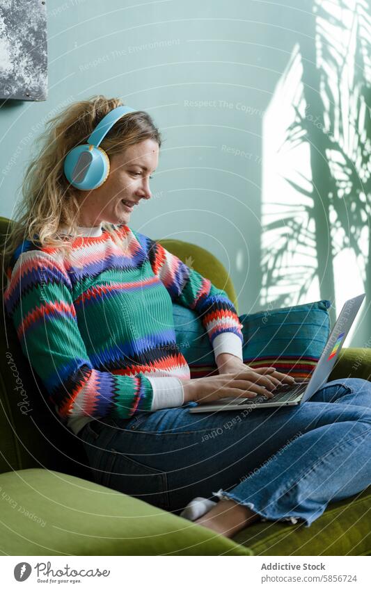 Junge Frau arbeitet aus der Ferne mit Laptop und Kopfhörern Sofa intelligentes Arbeiten heimwärts Fernarbeit bequem grün Natur-Illustration Schatten sitzend
