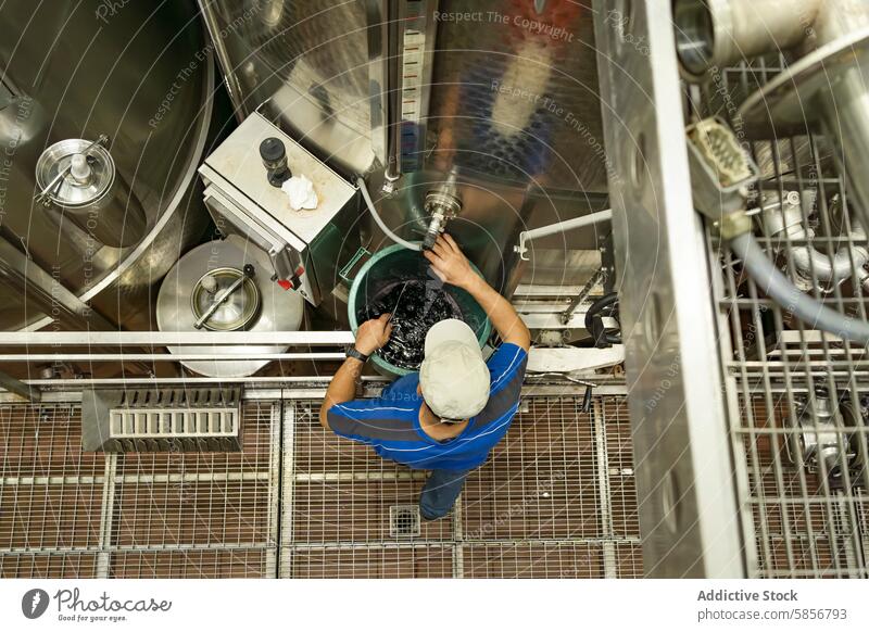 Winzer, der die Gärtanks von oben verwaltet Weingut Arbeiter Fermentation Tank Aufsicht von oben nach unten Ansicht Inszenierung Tradition Handwerk vorsichtig